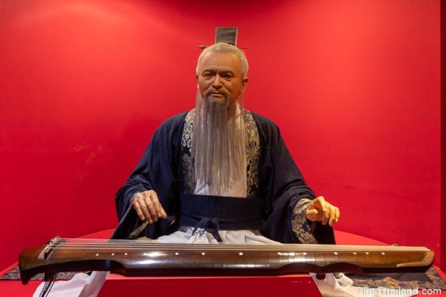 life-like statue of Confucius playing a guqin